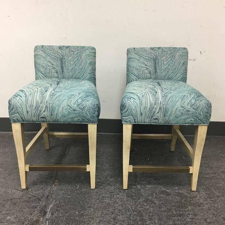 A pair of new Stacey counter stools by Pearson. Since 1941, Pearson has been producing bespoke furnishings for a demanding clientele. This versatile counter stool features blue paisley upholstery and linen finish legs. It adds an unexpected pop of