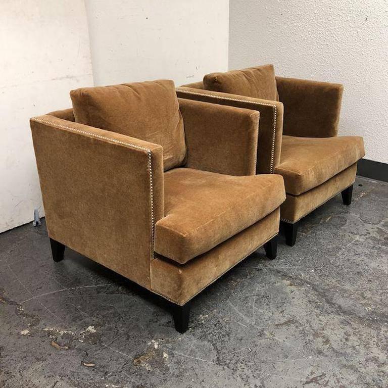 A pair of Hyde Chairs from William Sonoma. Sleek and stylish, upholstered in a Mohair Grade F in a camel color. They bring roomy comfort to smaller rooms and more intimate furniture groupings. The legs and loose back and seat cushion give it modern