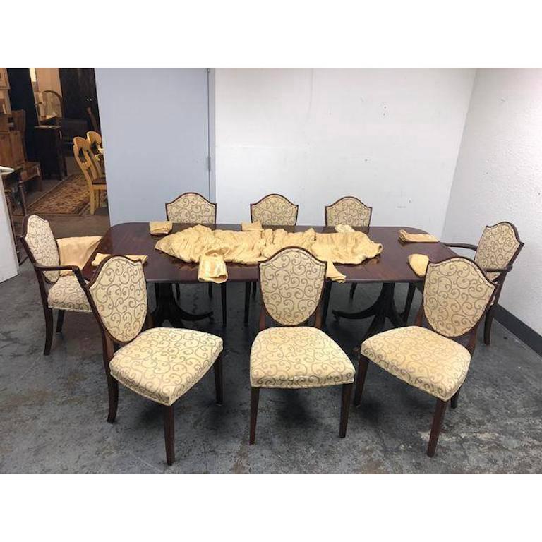 A William Tillman dining set that consist of the table and set of eight shield back chairs. Table has two extension leaves that are 18.50