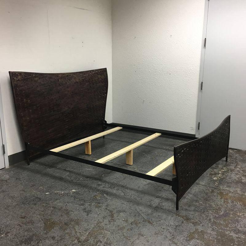 A sculptural queen sized bed designed by Dakota Jackson as part of the New Rhythms collection. Frame of headboard and foot board have an elegant organic form like the tail of a whale and are composed of woven steel straps with a bronze coating,