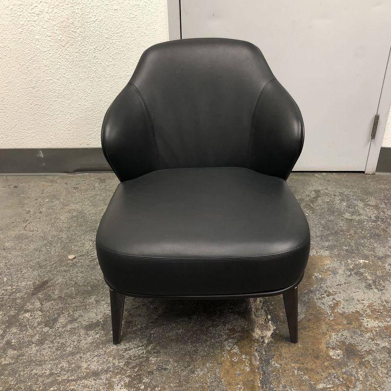 A Minotti Leslie armchair. The Leslie was designed by Rodolfo Dordoni for Minotti. The chair is comprised of an outer shell which is upholstered in Leather it is then laminated to the inner shell of the wing-back chair which has an additional softer