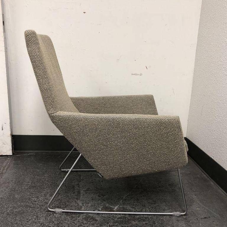 The Don chair and ottoman was designed by Gerard Van Den Berg for Label. Upholstered in a J. Robert Stock bouclé. The fabric is called Twist, the color is Charcoal/Champagne. The two pieces sit on tubular stainless steel frames, which keep them