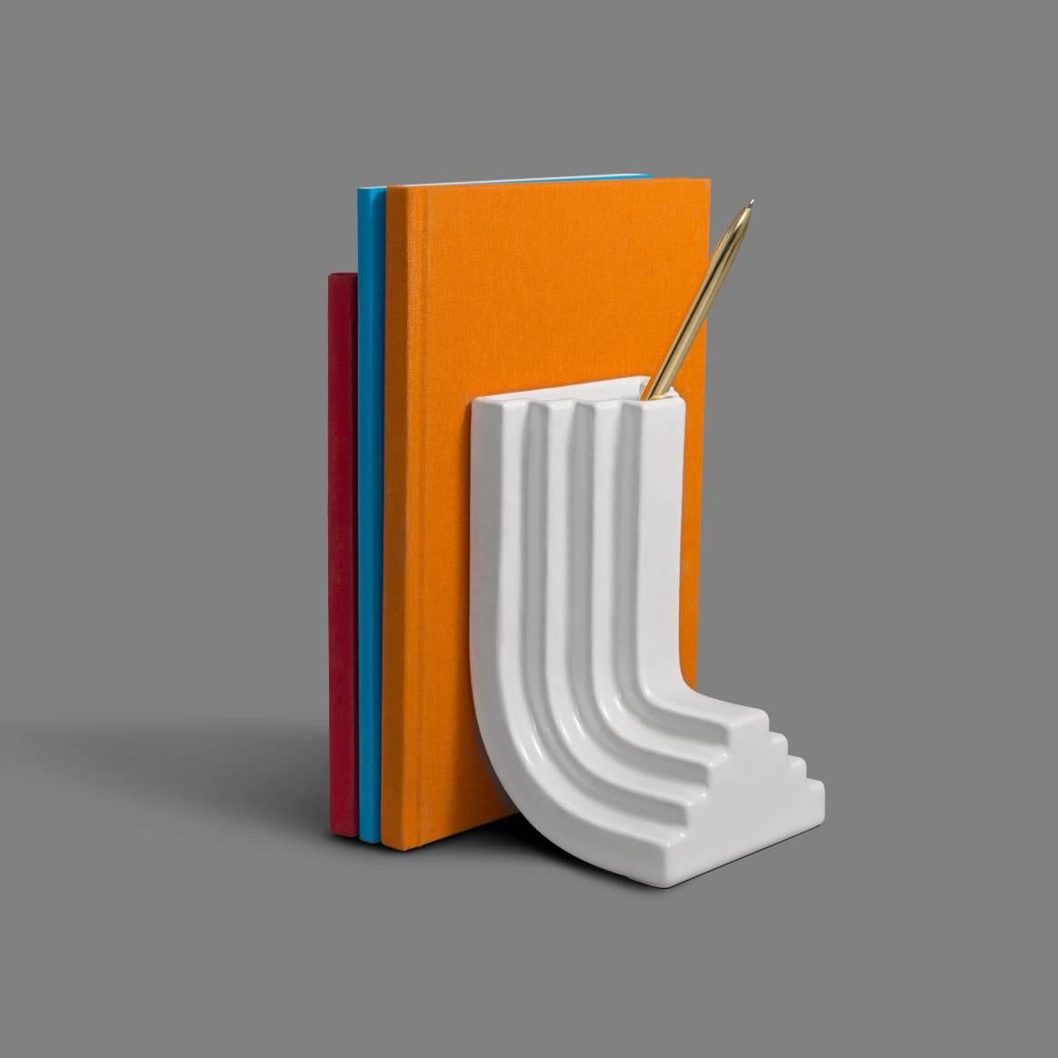 This bookend is a playful take on the various scales of design experience. While it is a tabletop item, its form references the monolithic nature of large-scale architecture. Its shape is inspired by the building elements and aesthetic features of