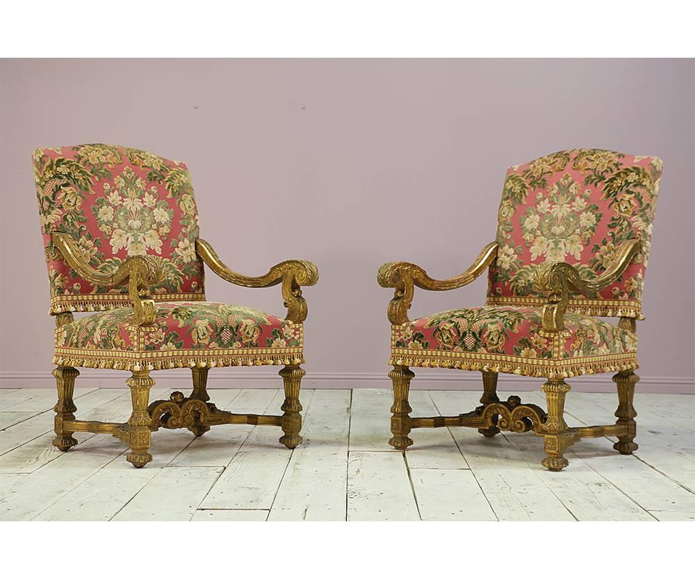 Gorgeous pair of late 19th century French Baroque-style giltwood fauteuils with finely carved decorations. Gilt finish is naturally distressed. The fauteuils have been recently reupholstered in a floral patterned cut velvet and finished with a