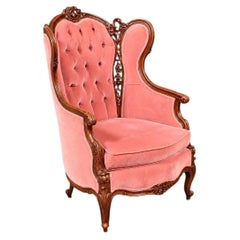 Sillón antiguo de estilo neorrococó victoriano, tallado en nogal y tapizado en terciopelo, con respaldo alto