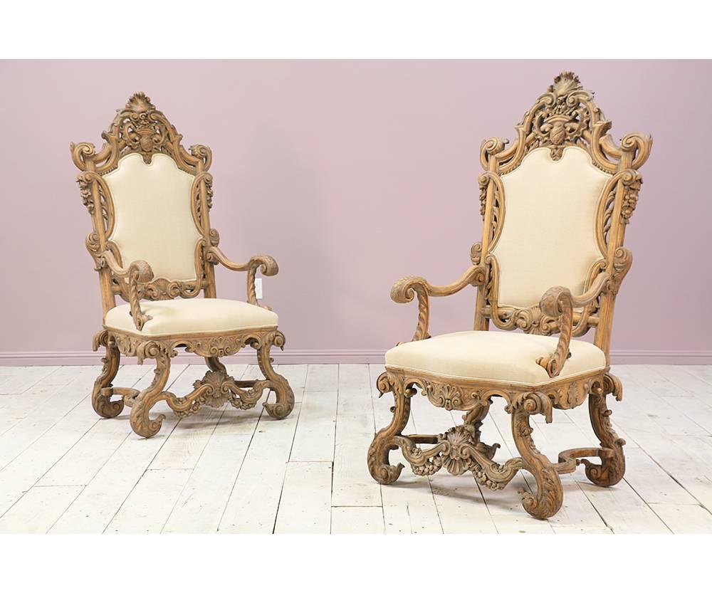  An outstanding pair of Italian 1930s throne chairs in the Renaissance style. Intricate carvings through out serve as a fine example of Italian craftsmanship and artistry. Distressed paint finish. Natural imperfections in new Belgian linen