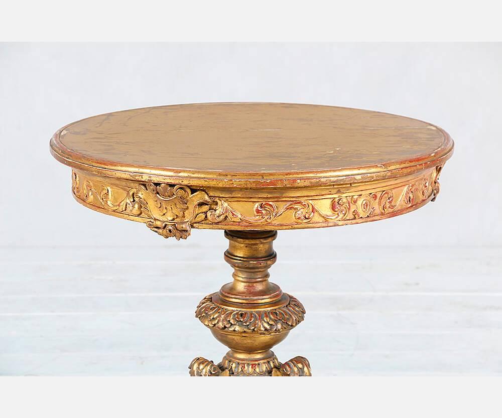 Gorgeous 1920s Italian giltwood pedestal or accent table in the Rococo style with intricately carved decorations throughout. Gilt finish is naturally distressed.
