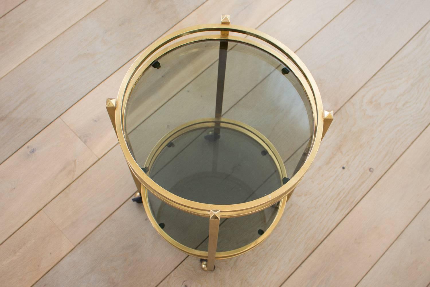 Mid-Century Modern, elegant, brass side table with two-tier smoked glass inlays. The table is easy to move due to the adjustable wheels underneath. Very practical due to its size yet very decorative.
Never enough gold we say.