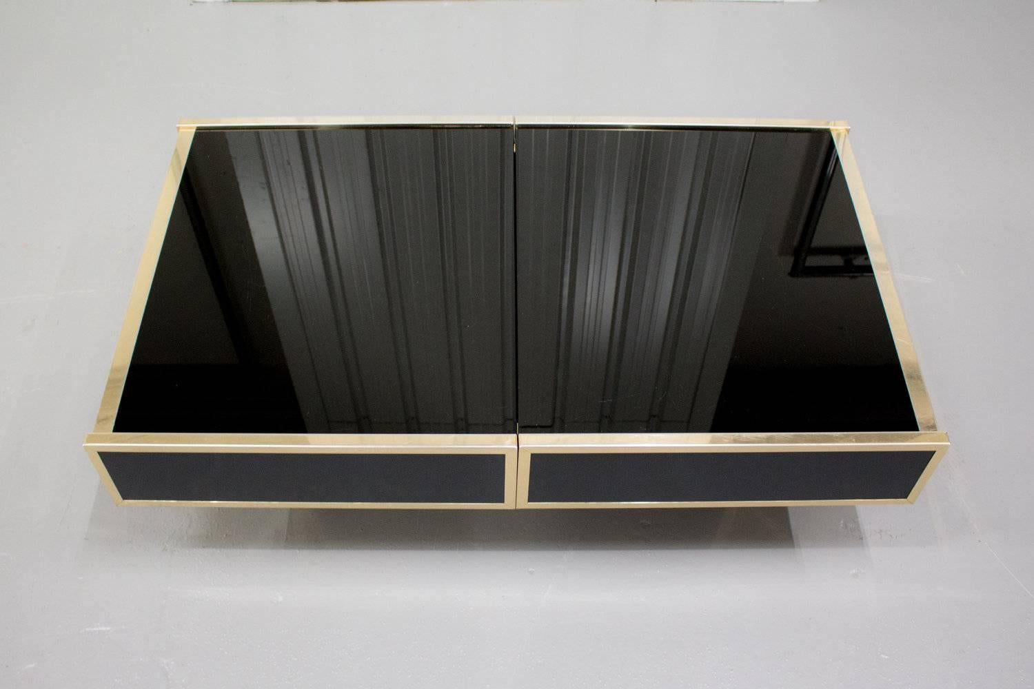 The coffee table of coffee tables. Willy Rizzo for Cidue black mirrored and lacquered extendable coffee table with brass detailing. This beautiful piece of craftsmanship is extendable to reveal a hidden dry bar on the inside of the table,