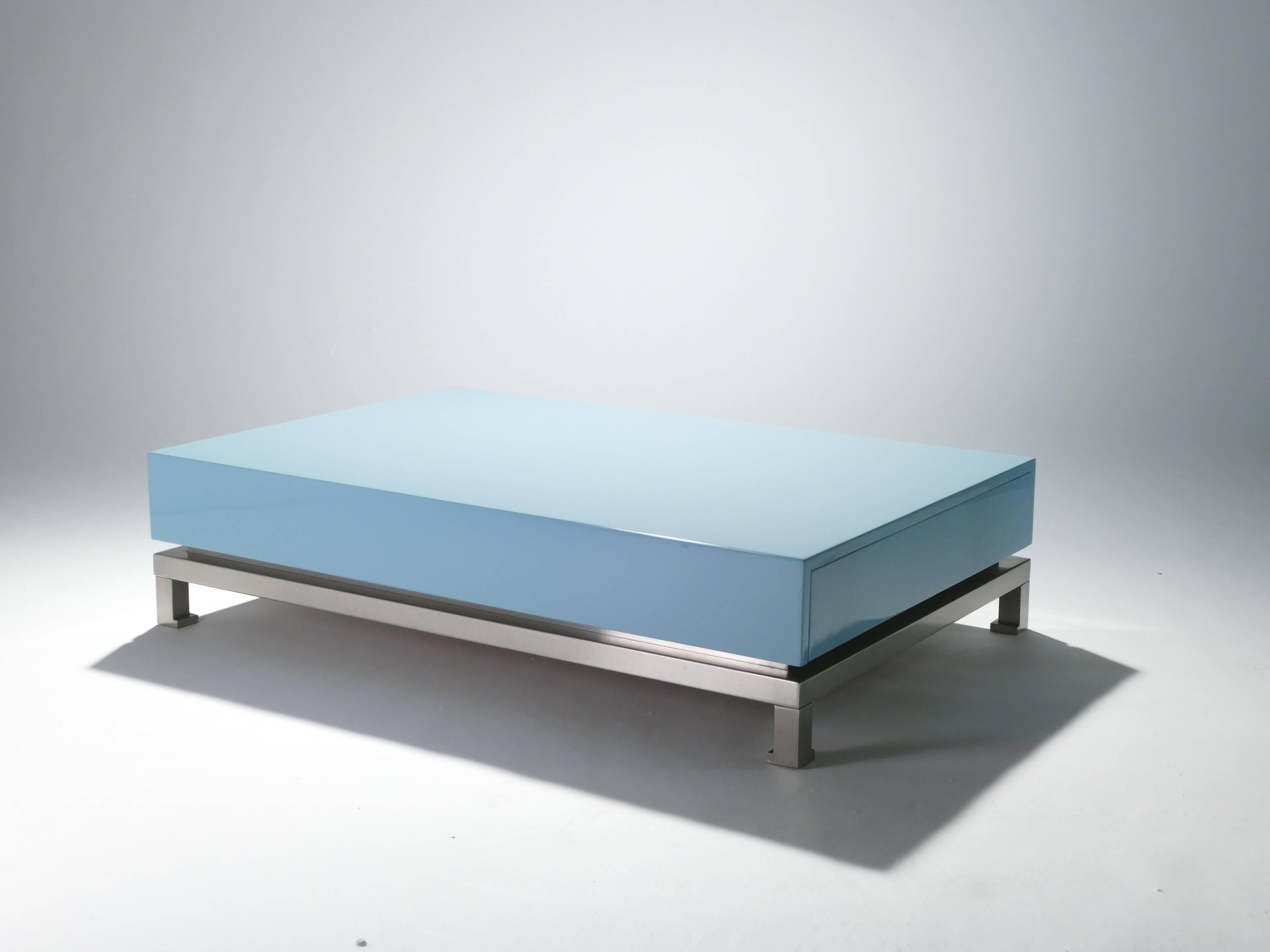 A creation of Guy Lefevre in the 1970s, this pale blue lacquer coffee table incorporates sleek and functional design. Mid-Century Modern with a pop of color, this table compliments a Minimalist or maximalist interior. Table is perched on slender