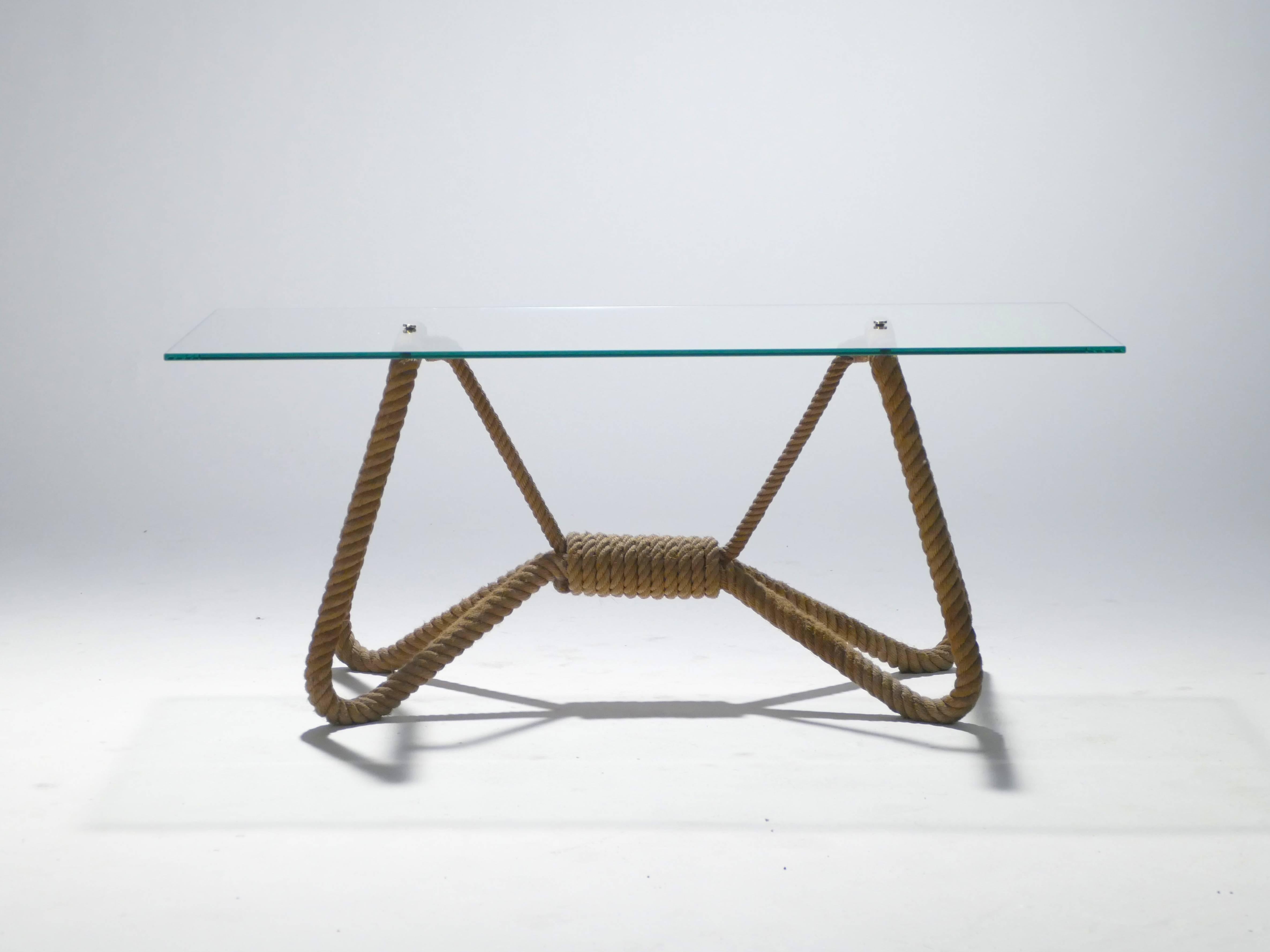 Ocean-inspired rope work, typical of Adrien Audoux and Frida Minet, forms the sturdy feet of the 1960s coffee table. Intriguingly knotted, the ropes are designed to look like a bow. The transparent glass top allows a view of the ropework’s striking