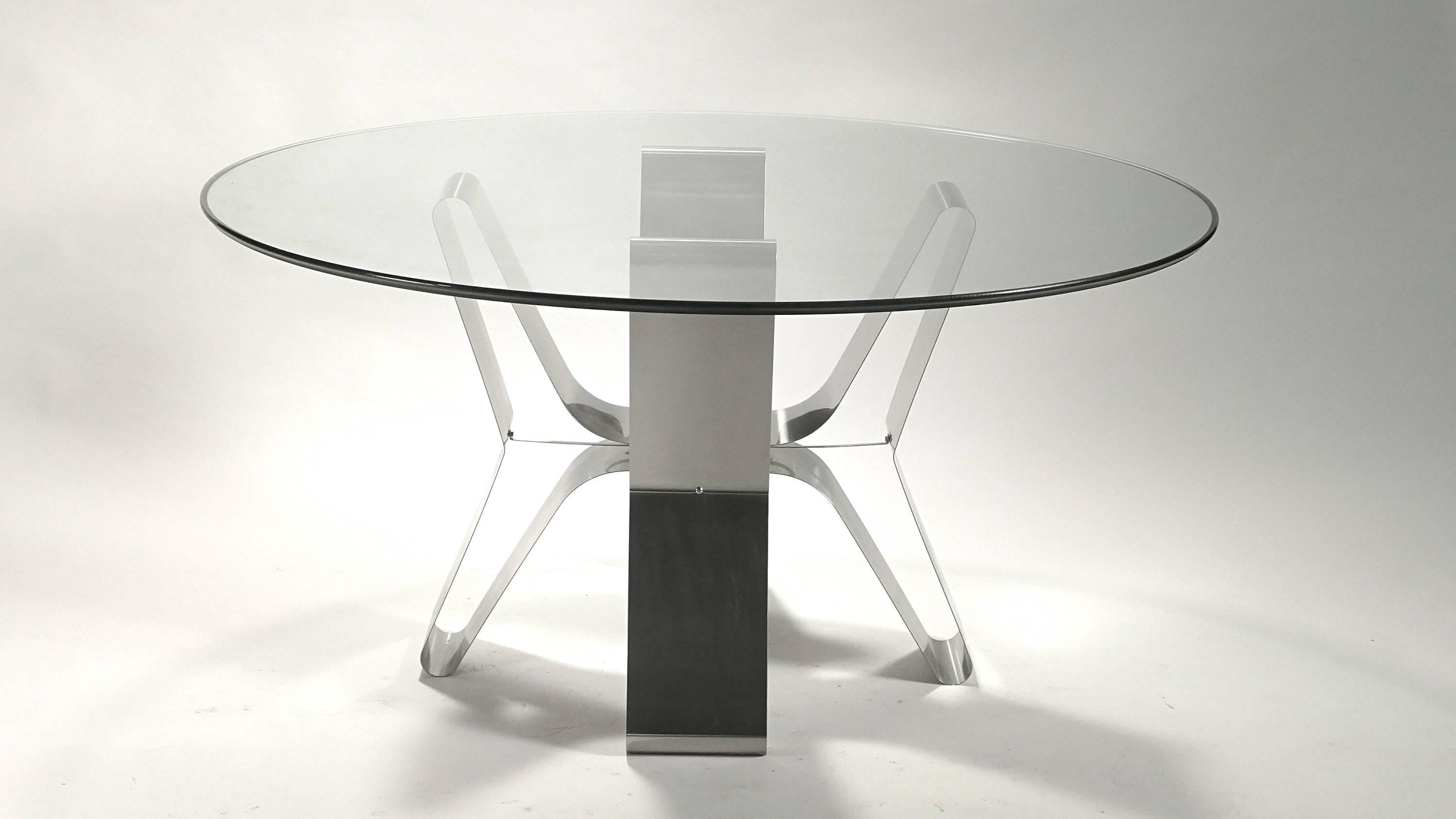 This extravagant contemporary dining table is perfect in every way. Curved in toward the table's centre, this iconic piece by French Modernist is made from bendable sleek brushed steel frame with an tempered original glass top that gives a timeless