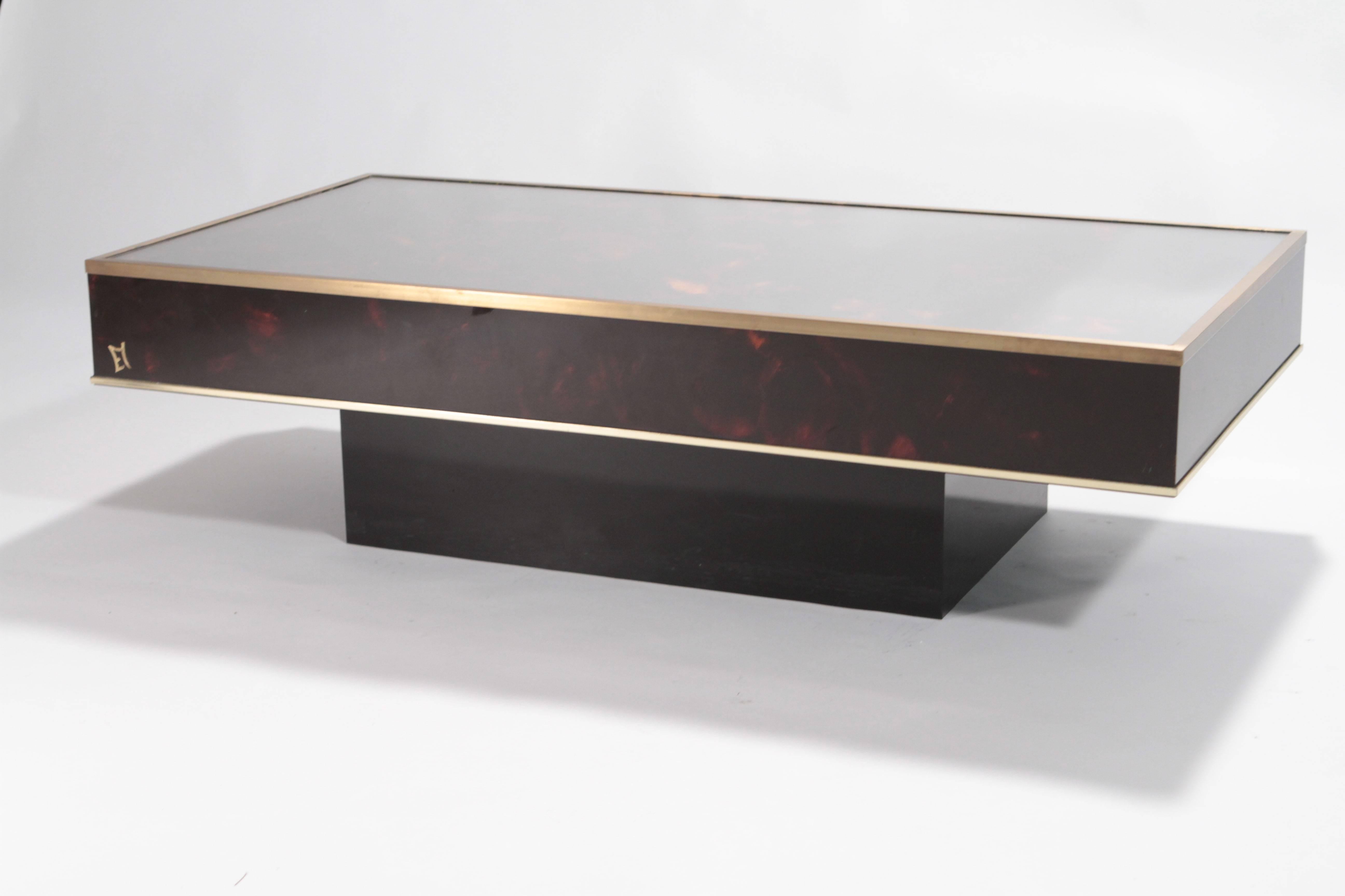 Heighten the modern look of your living area with this sophisticated coffee table in brass and plexiglass with tortoise pattern produced by the French designer Jean Claude Mahey for Maison Romeo back in the 1970s. It is stunning in either modern or