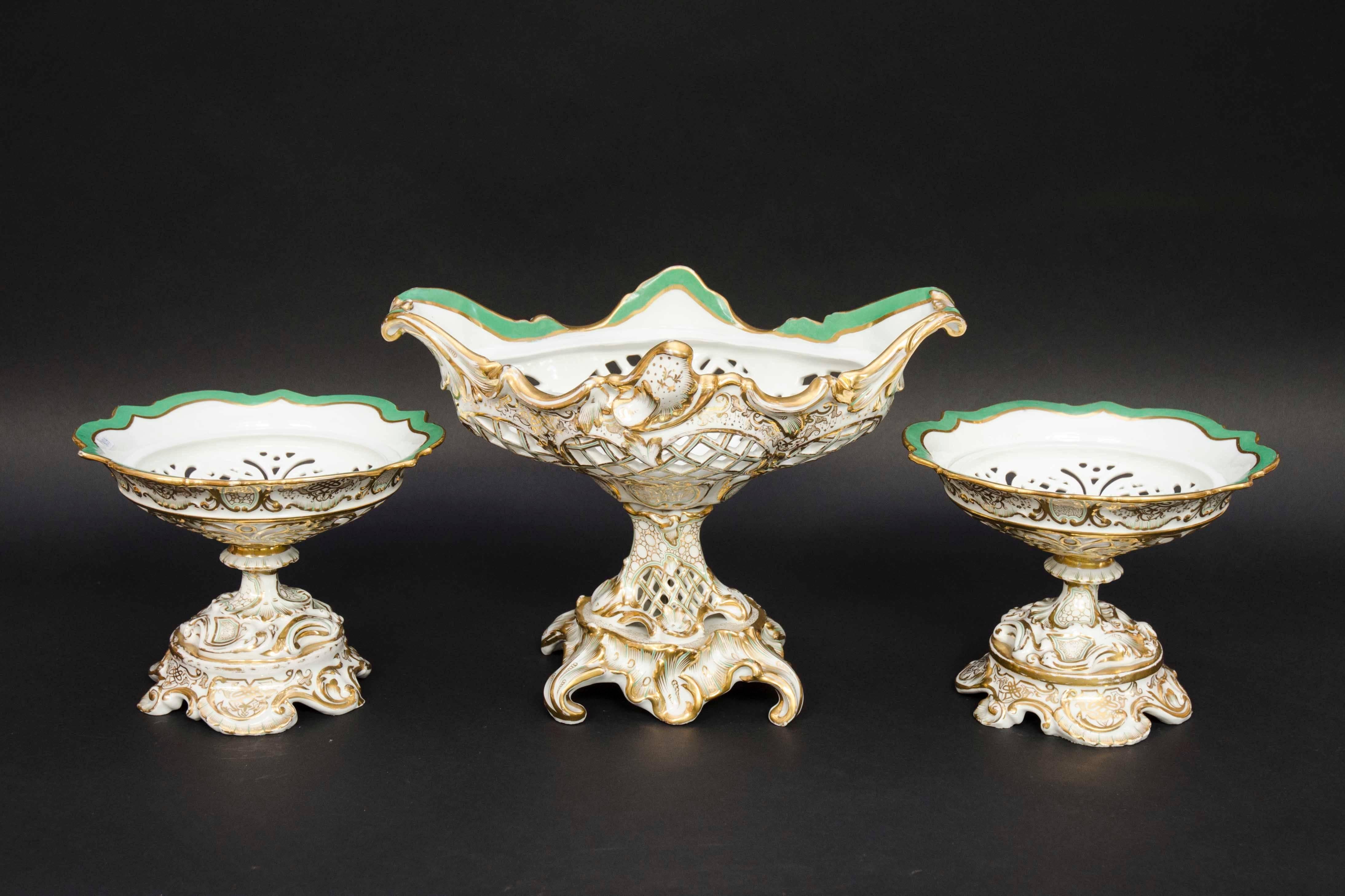Beautiful mantel garniture of open worked baskets on piedouches in the Rocaille style. Lots of movement in the white porcelain, enhanced with beautiful gildings. Green colored rim inside of the baskets. Signed by the porcelain manufacturer