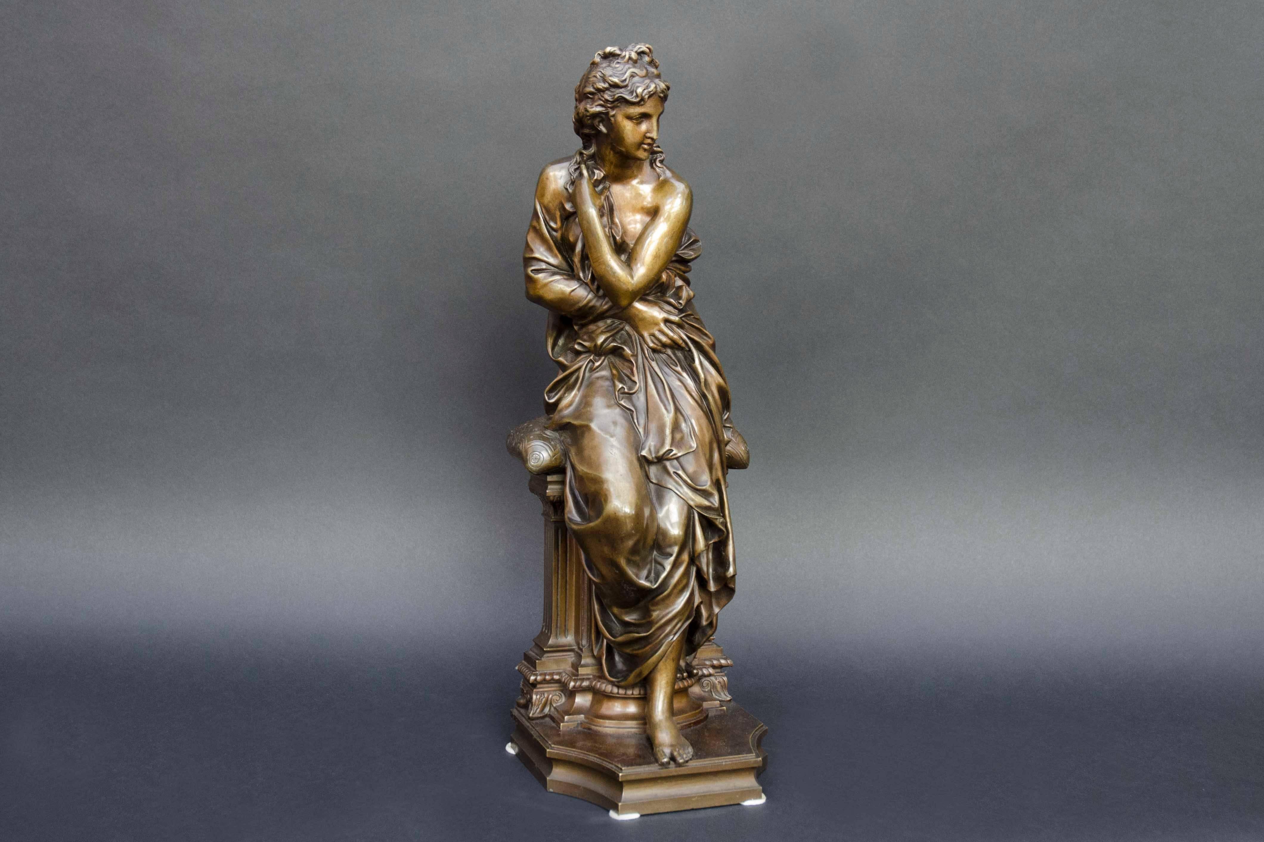 Beautiful bronze of a woman sitting on a pedestal and holding up a drapery as an antique divinity. Her hair is falling a little in her neck. A classical beauty. Signed on the terrace for Henry Etienne Dumaige (French, March 30, 1830-March 31,