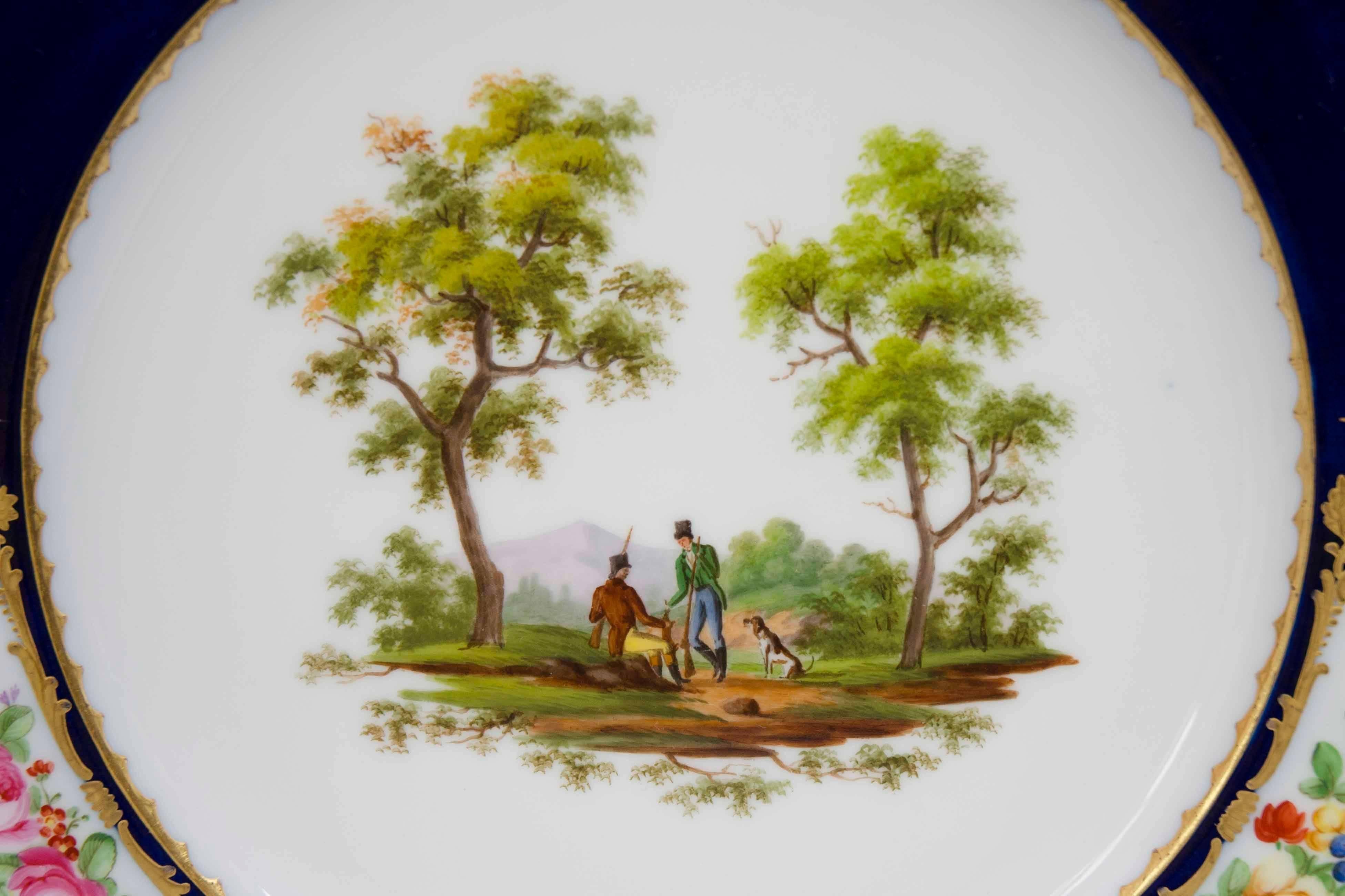 Pair of decorative porcelain plates entirely hand-painted in the centre with natural hunting scenes. Bleu ground borders with painted reserves with flowers. Gilt highlights. Great condition.

Dimension: diameter of 25 cm.

Markings at the back,