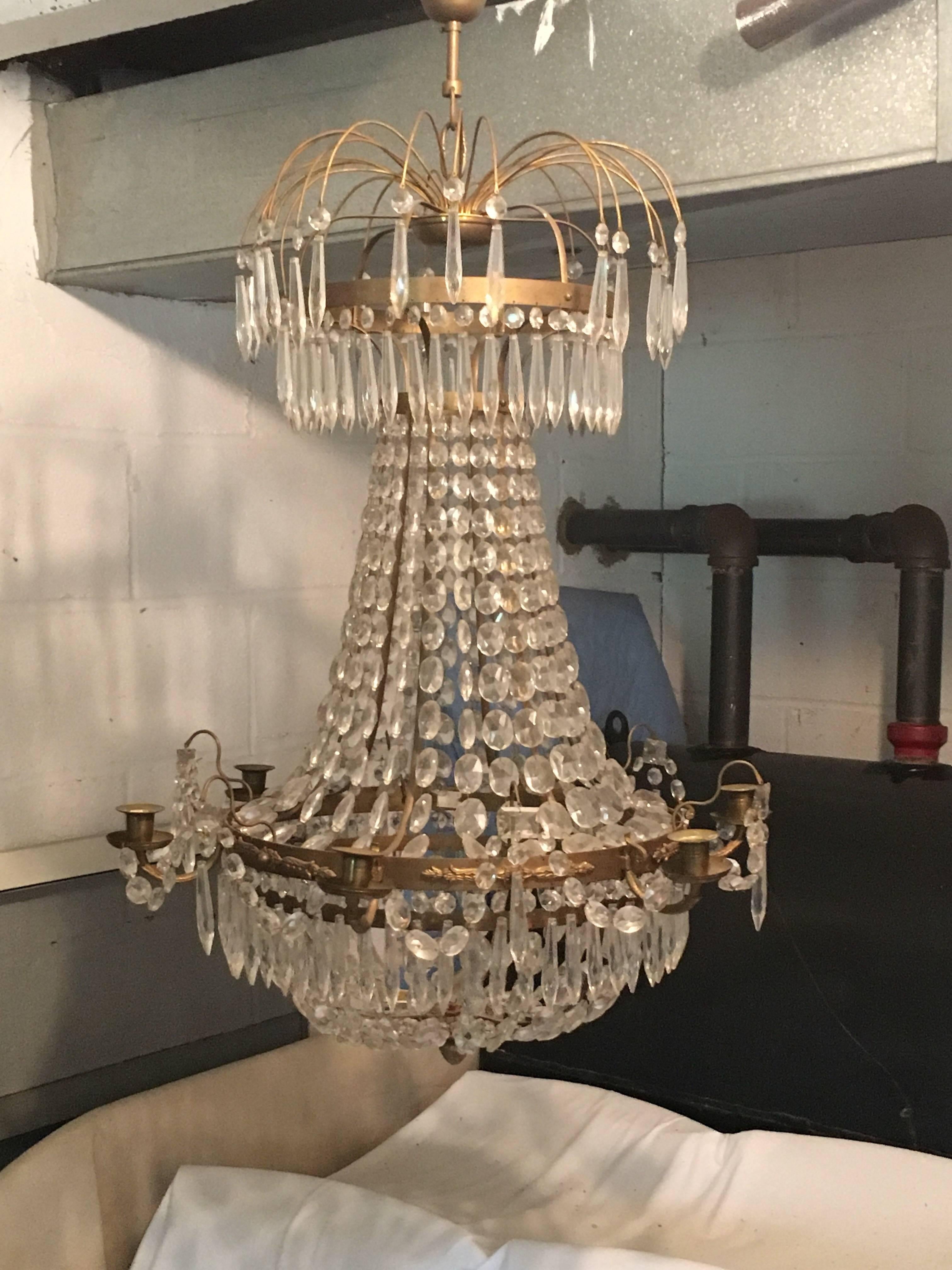 Absolutely gorgeous Swedish brass and crystal Gustavian style chandelier, ca. 1900. This piece has never been wired for electricity and retains its regal splendor as a candlelit chandelier. Would be a stunning centerpiece in a city or country dining