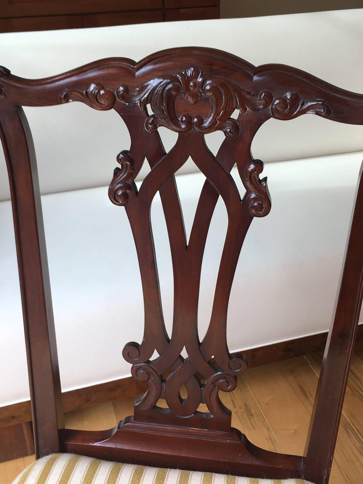 Absolutely charming pair of Danish Chippendale style side chairs, done in mahogany, circa 1870. Carved and pretty floral back splat, foliate knees, claw and ball feet in the front, saber legs in the back.

Very good antique condition, minor