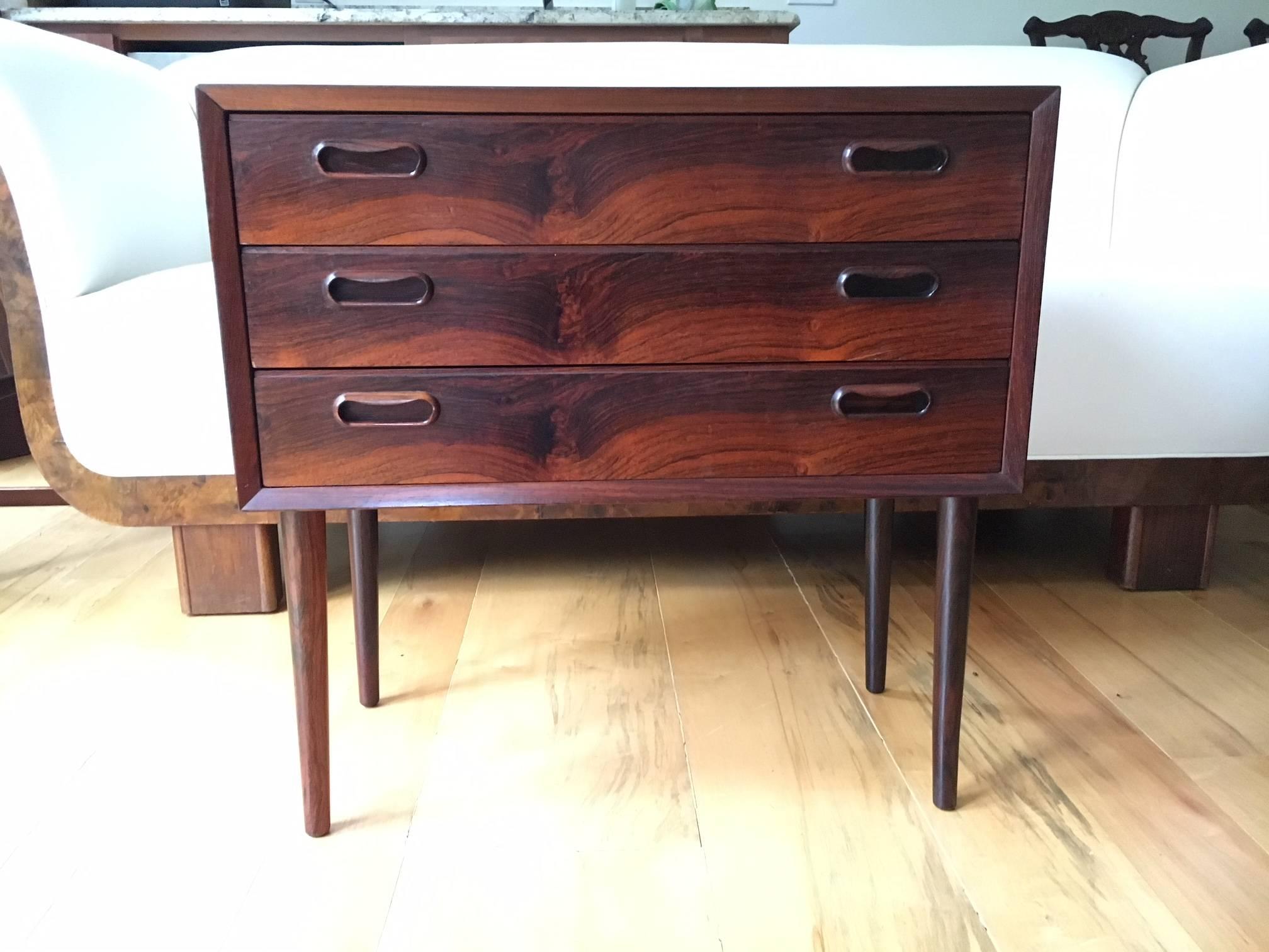 Fabulous Danish modern rosewood commode, beautifully veneered. Chic, darling and very striking, this little piece will add flair and function to any room. 

Of note are the beautifully designed and grooved drawers, which highlight the inimitable