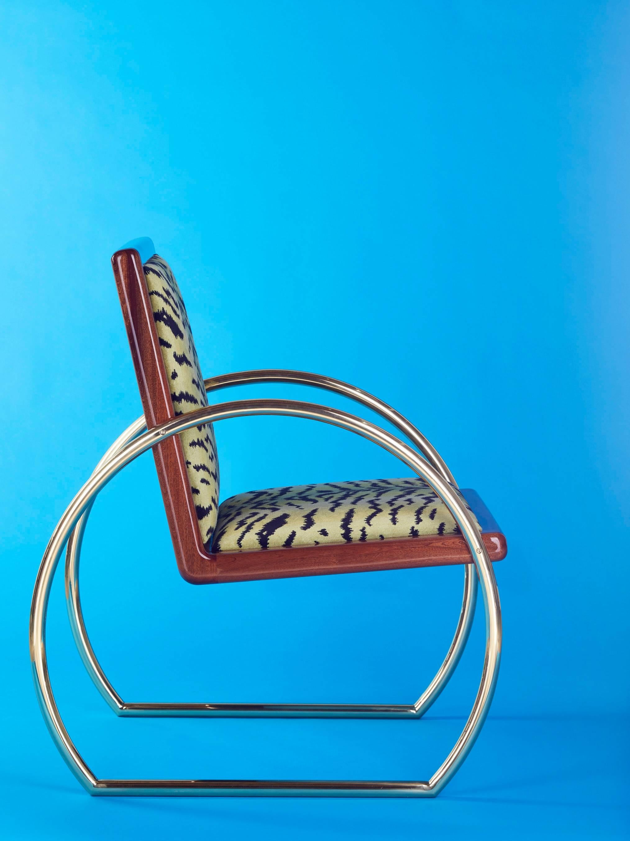 Der D-Ring Lounge Chair ist ein von der Art déco inspirierter Sessel aus Mahagoni, massivem Messing und Samt. 

Das honduranische Mahagoni ist mit mehreren Hochglanzlackschichten lackiert. Die Armlehnen und Beine sind aus hochglanzpoliertem,