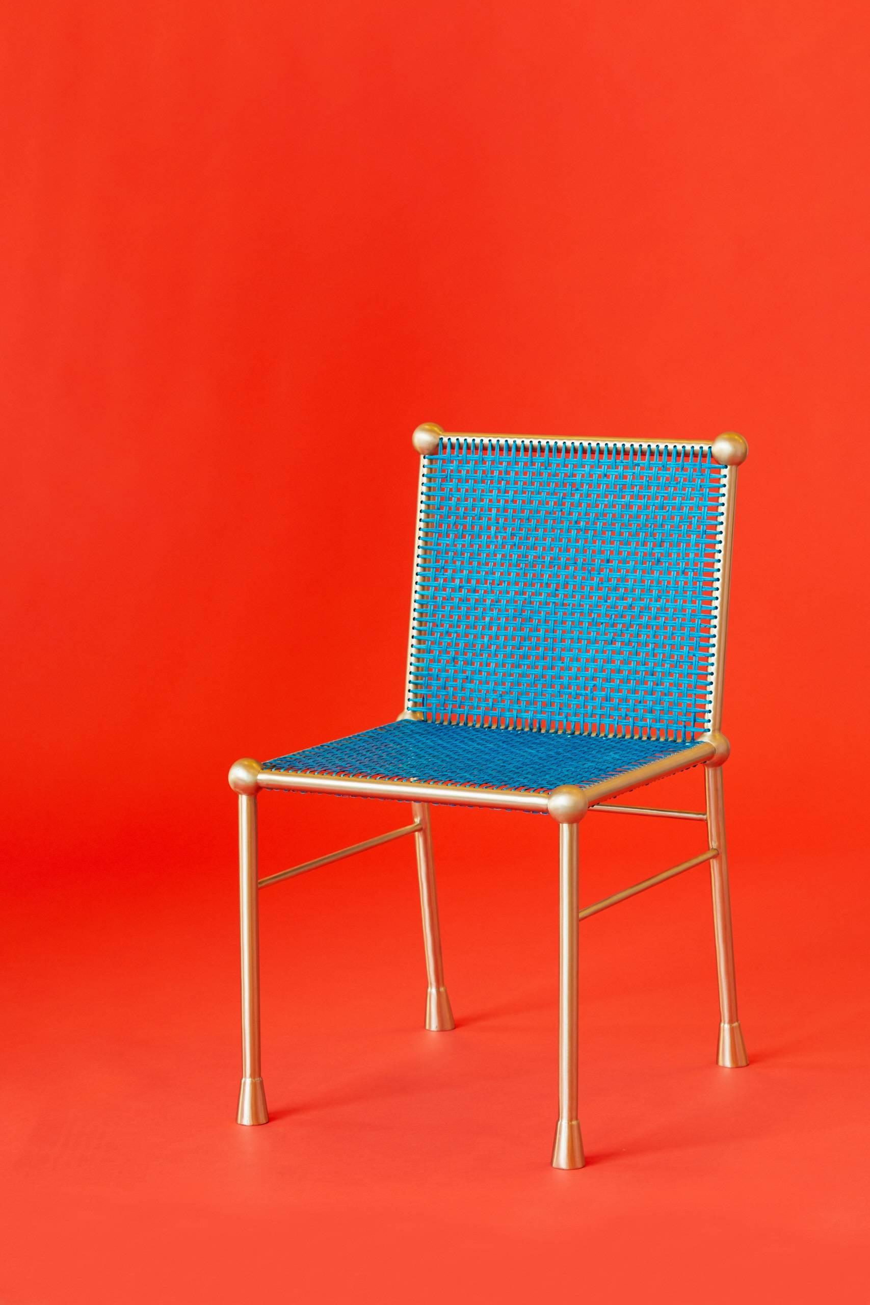 The BC chair was built and designed by Troy Smith. This one-of-a-kind chair is made out of solid brass and hand-woven hand-dyed blue cane. This chair was hand-built with the help of CNC technology and traditional metal joinery. The chair has a satin