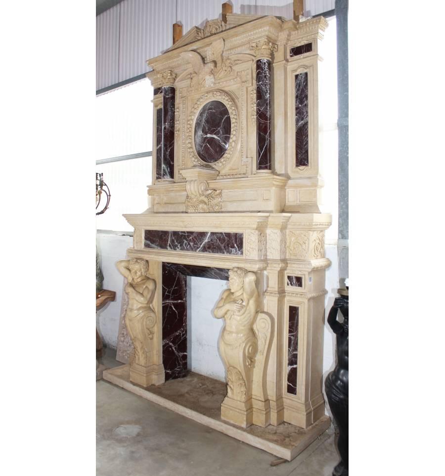 Monumental neoclassical fireplace mantel hand-carved in Egyptian yellow and Alicante red marble. Flanked by two Atlantes sculptures, decorated with hunting bass-relief and topped with an eagle. The neoclassical style is marked by the use of