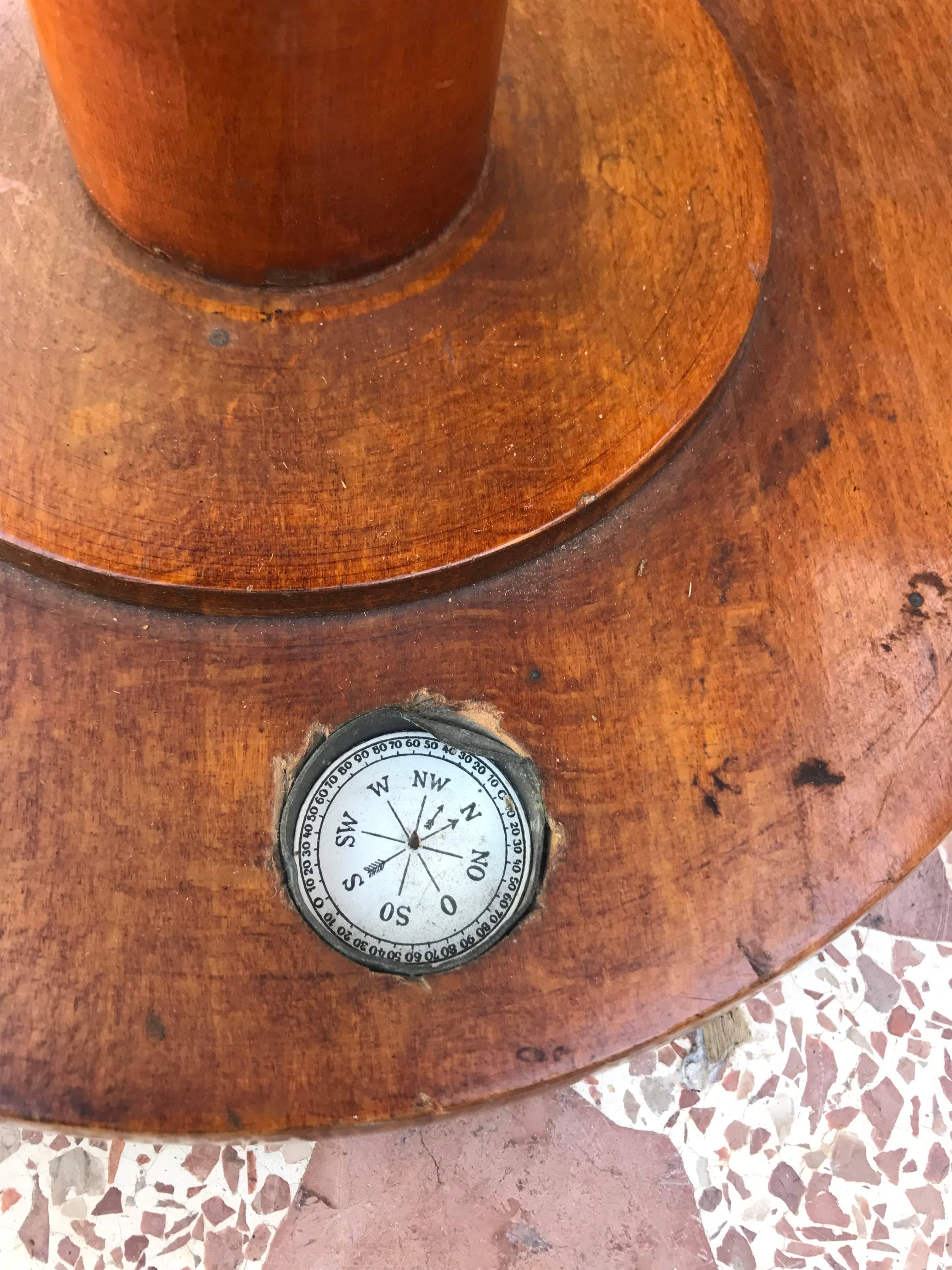 The wooden base has an embedded compass and supports the globe on a bronze stand.
      