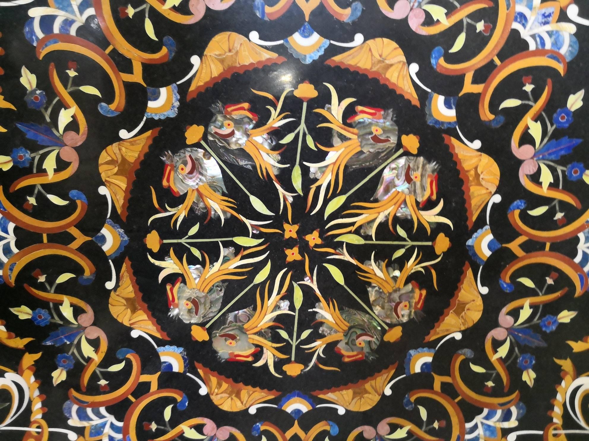 Reproduction artisanale d'un motif ornemental italien des années 1700 sur un plateau en marbre noir belge. Des vases avec des fleurs, des coquillages, des poissons et une myriade d'éléments sont confirmés par l'utilisation astucieuse de la Pietre