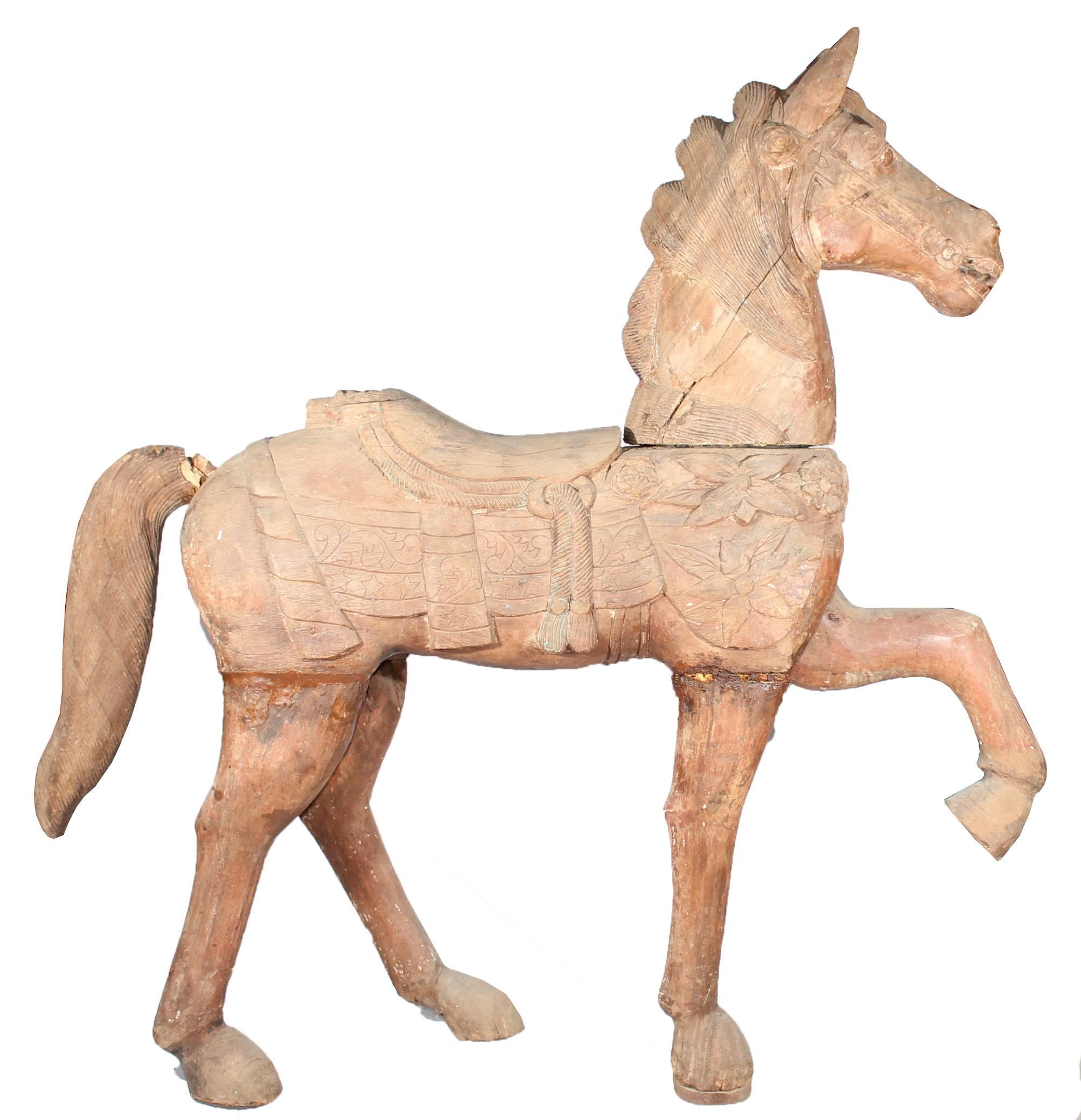 Hand carved wooden trotting horse with remnants of the original painting.
    