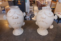 Coppia di grandi vasi in ceramica smaltata color avorio con decorazioni a rilievo