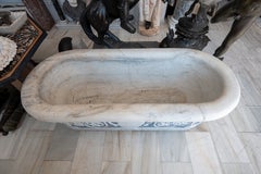 Vasca da bagno in marmo intagliato con decorazioni in marmo blu e rilievi.