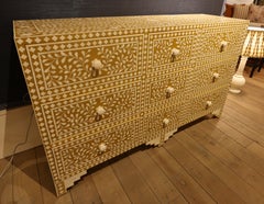 Credenza intarsiata con nove cassetti su sfondo color senape