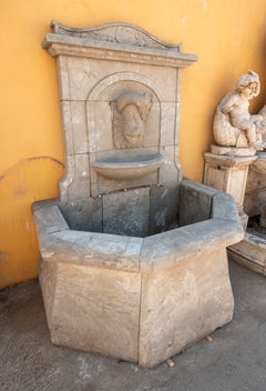 Fontana da parete in stile classico con vasca ottagonale in marmo scolpito.