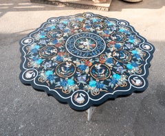 Tablero redondo de mármol negro con incrustaciones florales de pietra dura italiana.