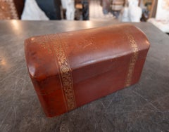 Caja vintage de los años 50 de cuero en tonos rojizos, con tapa abombada y bandas florales