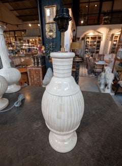 Lampe de table couleur ivoire, avec un pied nervuré et une base en gradins
