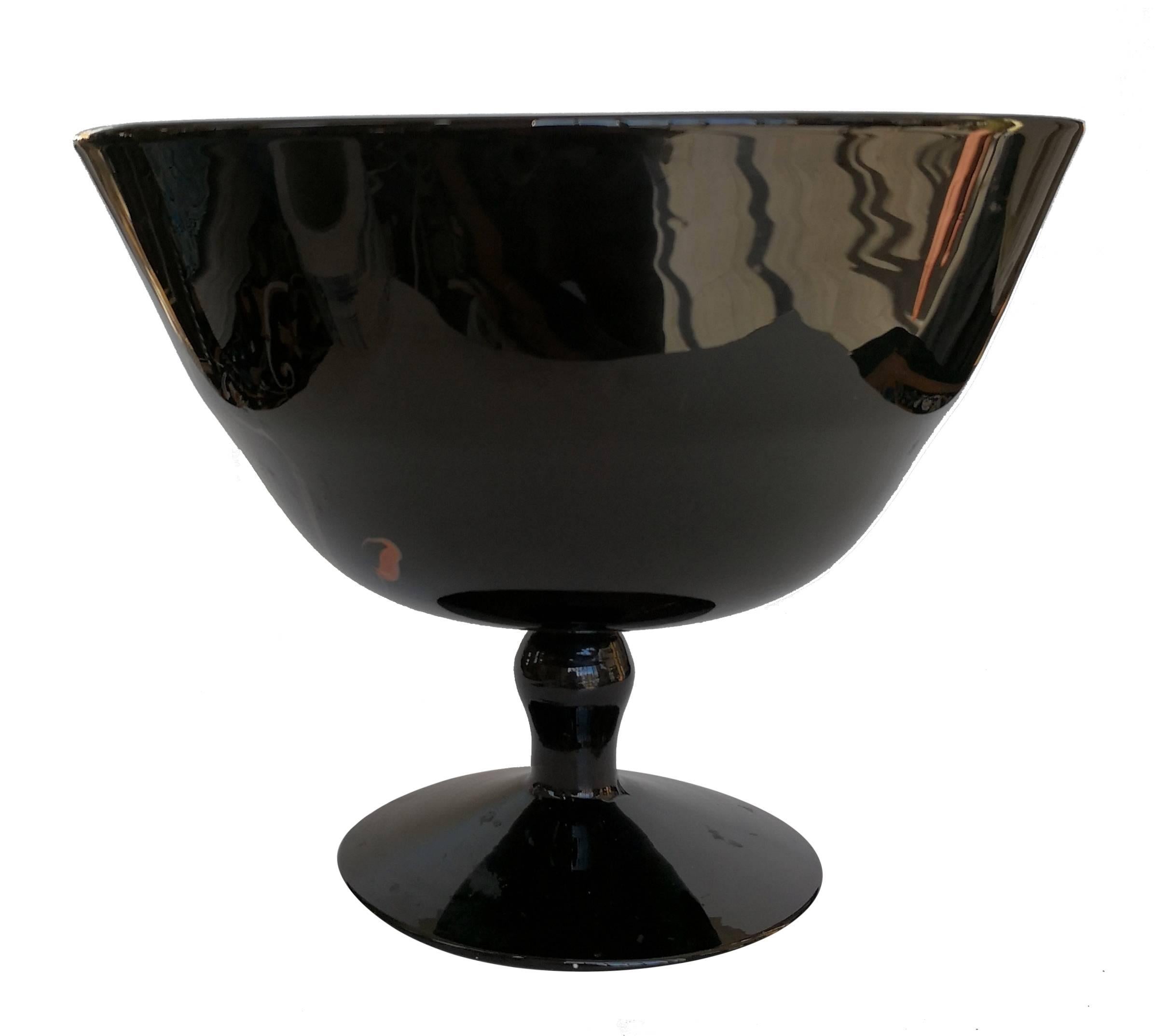 Opaque black glass with irregular brown veins making it unique. The base has a mark with the initials M and V overlapping. 
