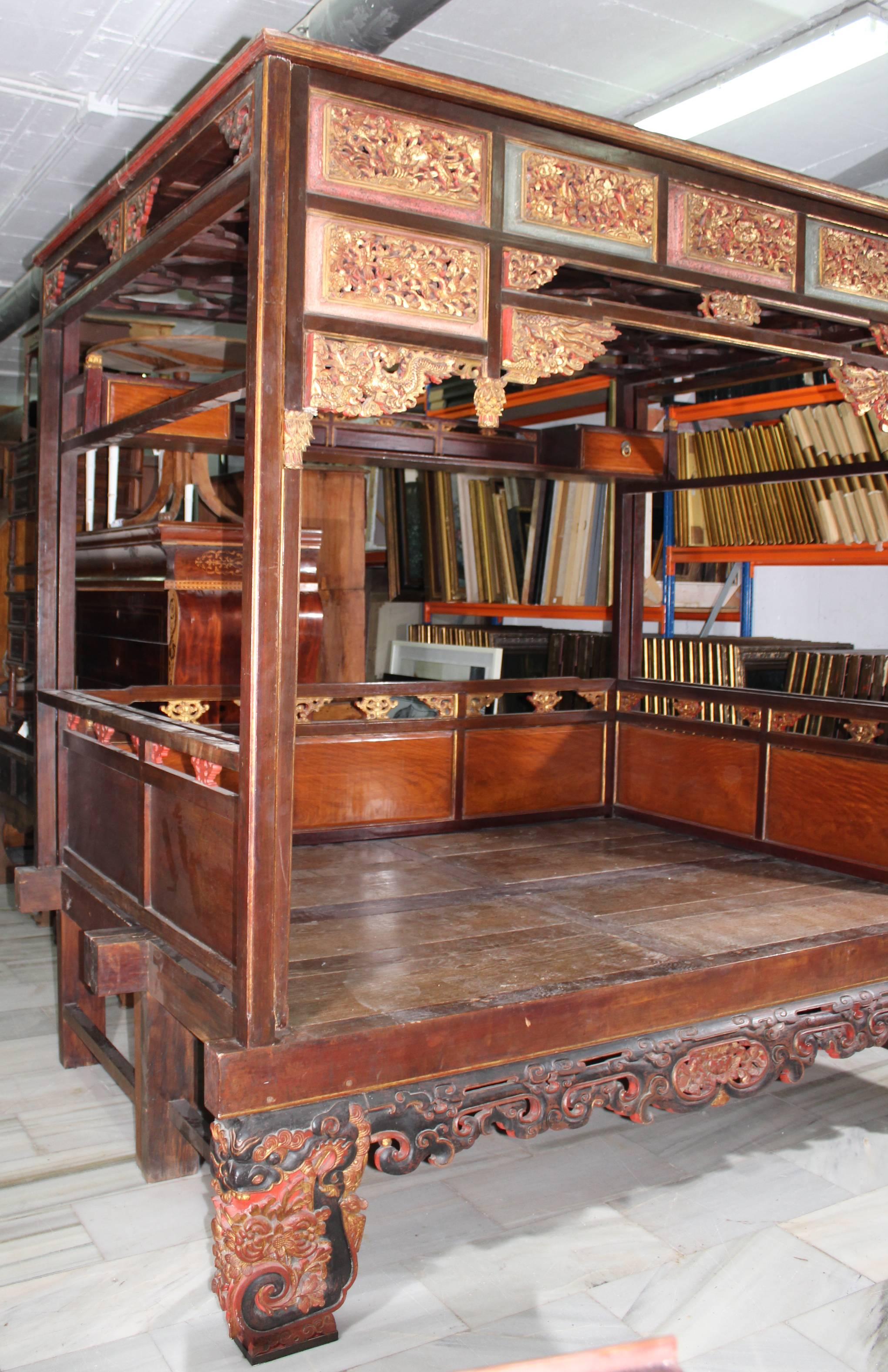 This is a wonderful example of a canopy bed from Shanghai Province, China. Made of Chinese Northern Elm, this bed features hoofed feet and multiple floral carvings. 

The exterior is heavily decorated with gold leafing, carvings, ornate carved