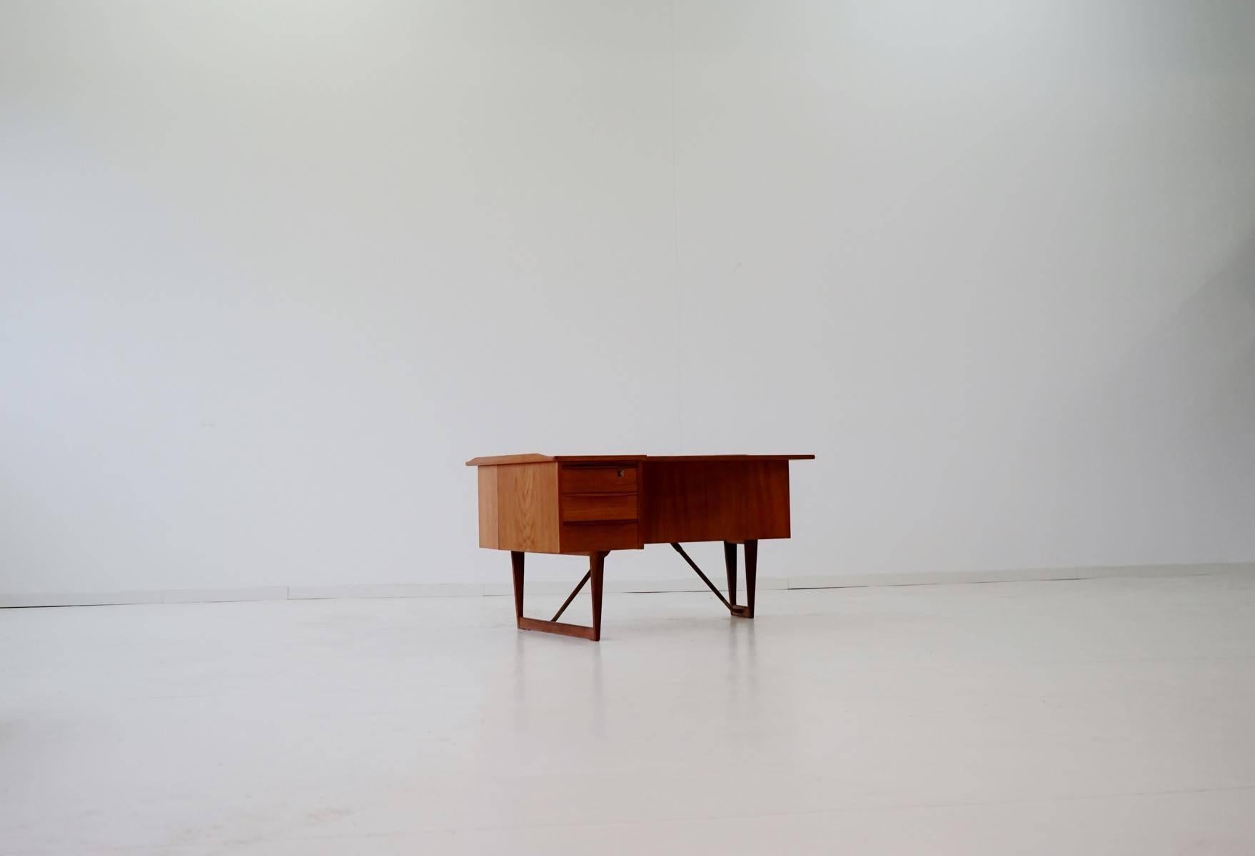 Peter Lovig Nielsen Teak Boomerang Desk Hedensted Møbelfabrik
This midcentury design Classic was made in Denmark by Hedensted Møbelfabrik. It is very handy. Three lockable drawers on the front and shelves (one with a door, lockable) on the back of