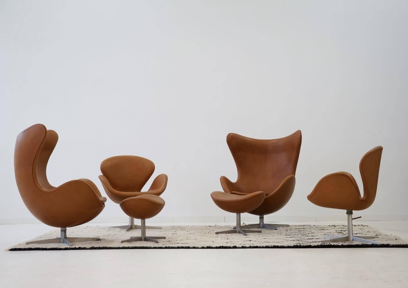 Egg chair with ottoman and Swan chair by Arne Jacobsen, Fritz Hansen in leather, 1960s
Set of two Egg chair and two ottoman from early production series. With old foot, swiveling. Two Swan chair with swiveling and height-adjustable feet.
The set
