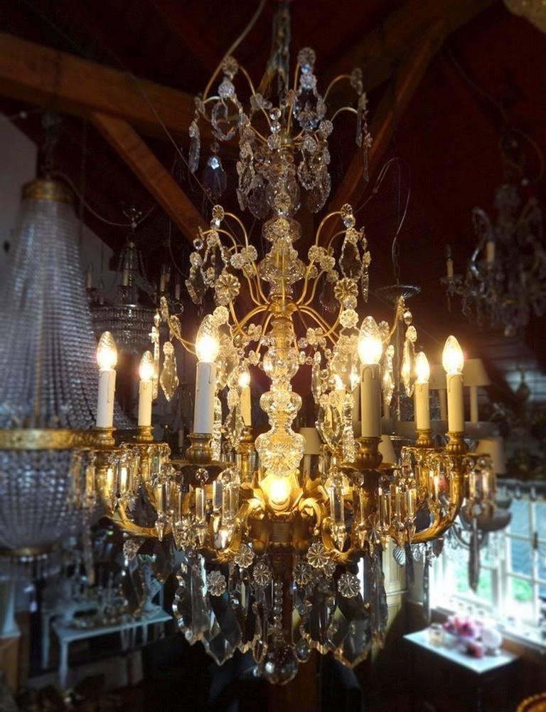 Spanish chandelier of bronze and crystal with very nice and large crystals. Twelve-light including four in the center. Beautiful detailing in bronze frame. Completely restored. 
 