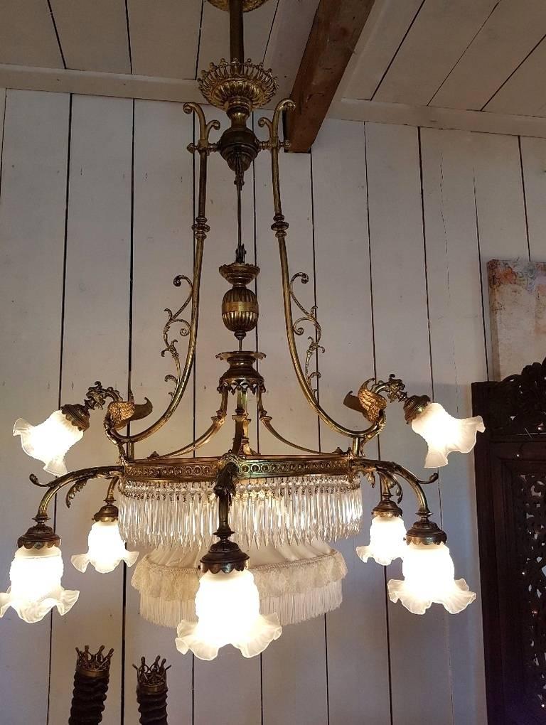 French chandelier with nine lights and in the center a pulley-system so you can lower the light in the midst. On the top of the ring two lights with dragon ornaments.
 