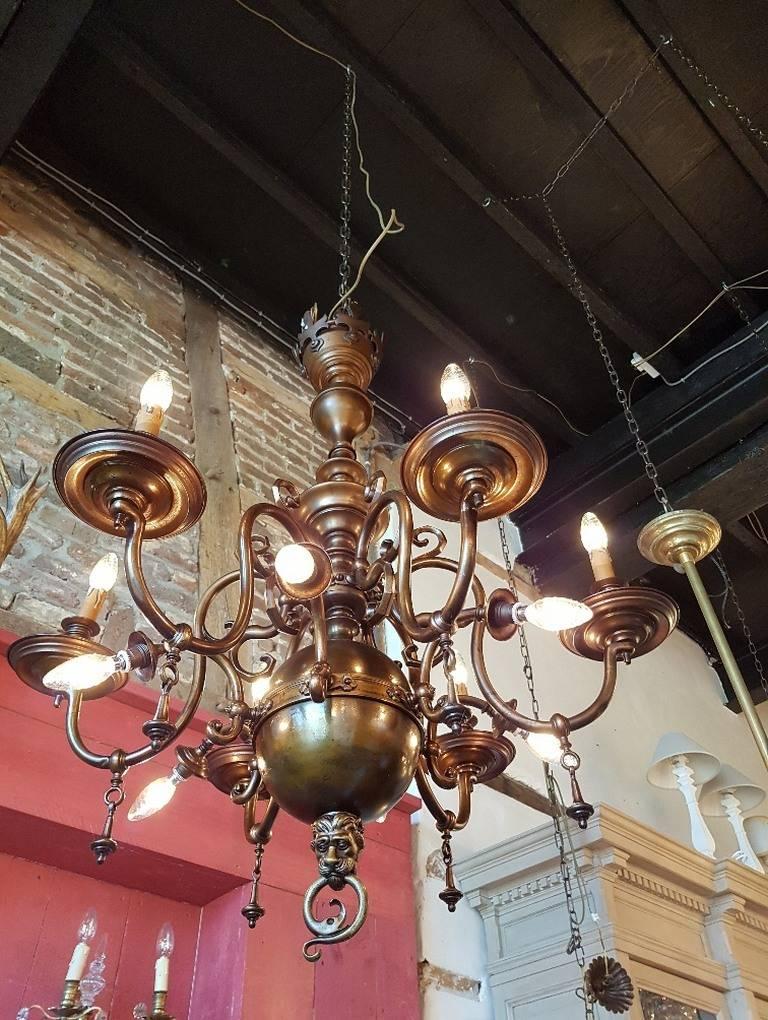 Belgium chandelier in perfect condition. bronze in nice patina. Twelve lights with nice ornaments. Six-light points are facing down 
This is just one of the collection of 1000 chandeliers, ceiling lamps and wall lightning.