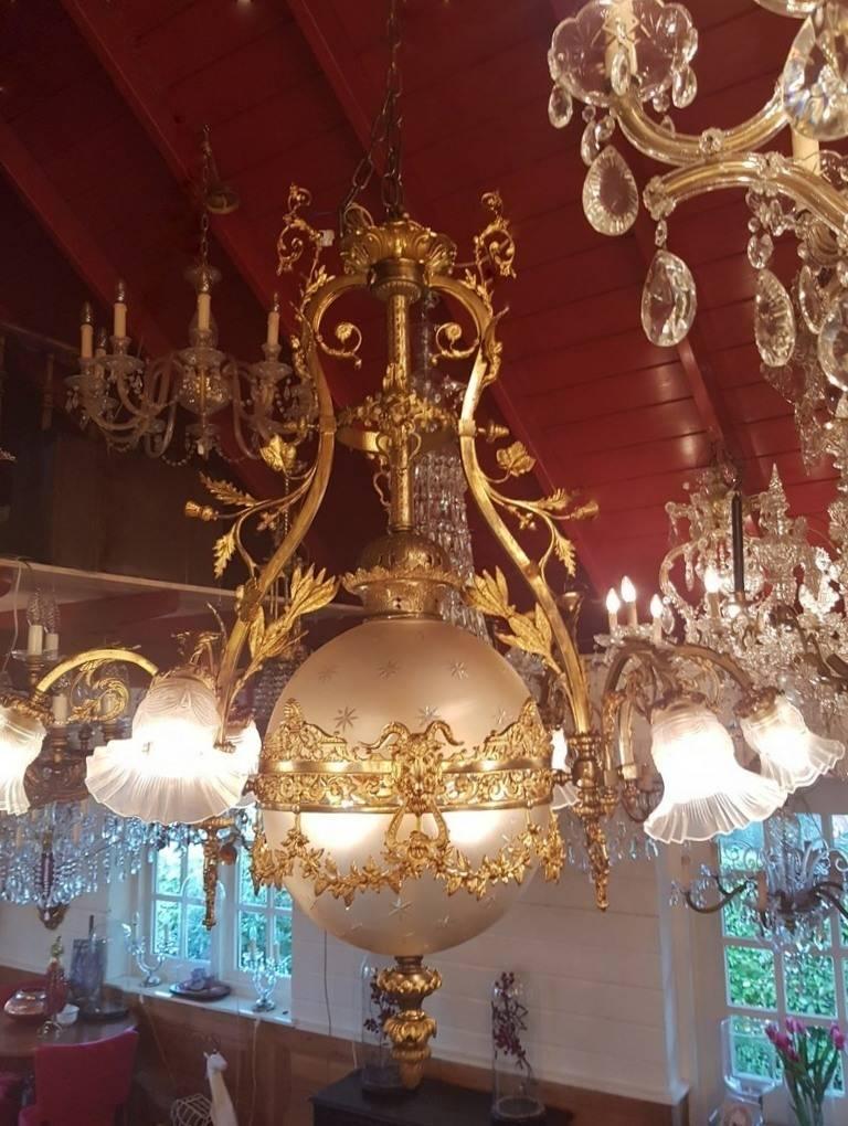 French bronze Empire style chandelier with beautiful globe from Victorian cut-glass. Total seven lights. Nice detailing like guirlandes, angels etc.
This is just one of the collection of 1000 chandeliers, ceiling lamps and wall lightning.