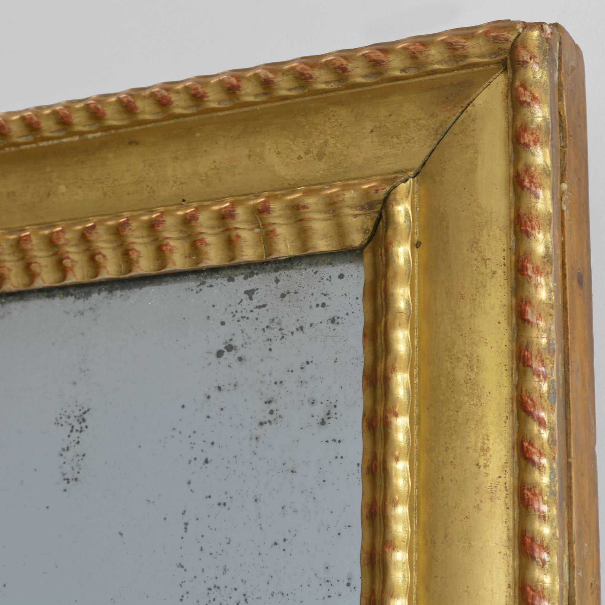 Stunning! Untouched for 200 years, this grand old portrait mirror offers a nice example of antique mercury glass. You can easily see the shimmering silver flecks in the layer behind the glass, and of course some oxidation has occurred over the