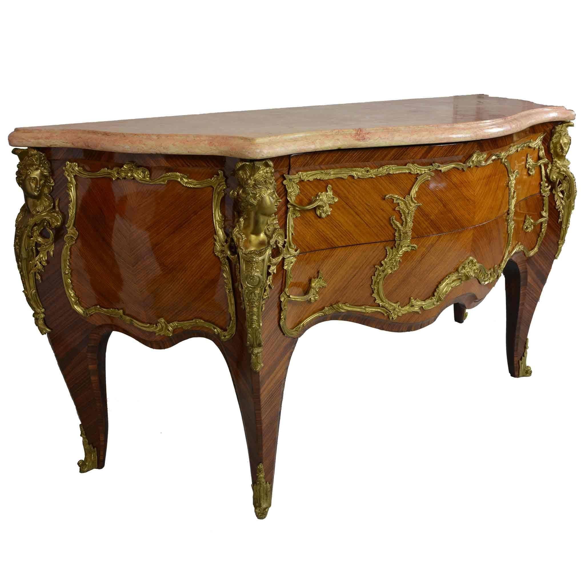 An absolutely stunning period piece, this majestic French commode features a luscious beveled rose marble top, strongly grained wood veneers, and plentiful gilded brass ornamentation. The moment it caught my eye, I knew I couldn't leave it behind.