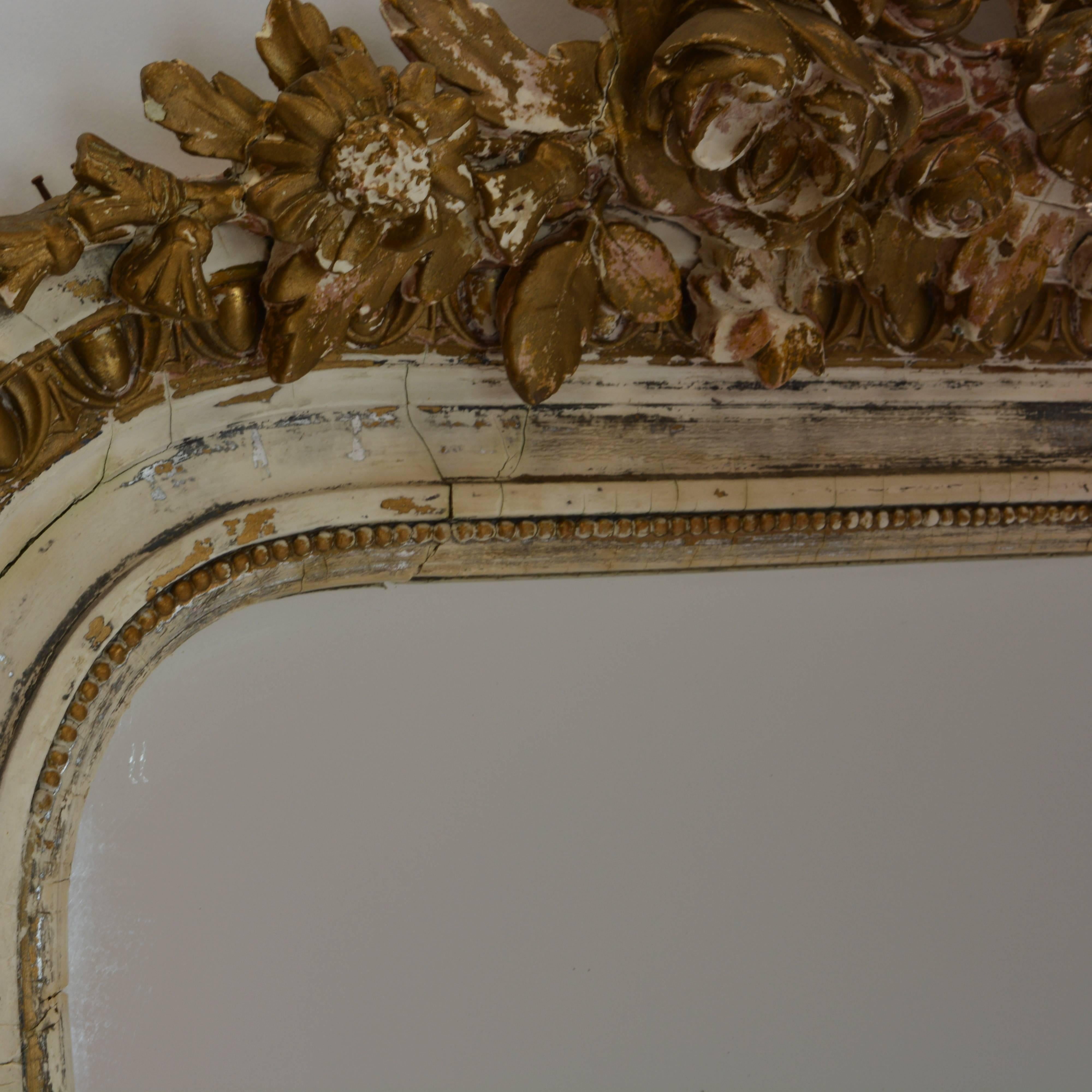 More than 6' tall and 3-1/2' wide, this stately old wall mirror from circa 1840 will provide a commanding presence in any room. Wonderfully detailed wooden frame and backing, crowned with an ornate bird design. Time has taken some of the original