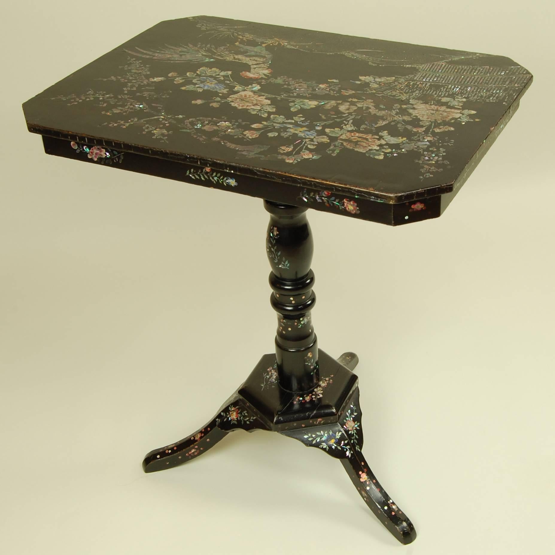 Crafted with painstaking attention to detail, this small wooden table would be a conversation starter in any era. Its ebony finish is studded with thousands of select mother-of-pearl fragments, all artfully arranged to form an extraordinary,