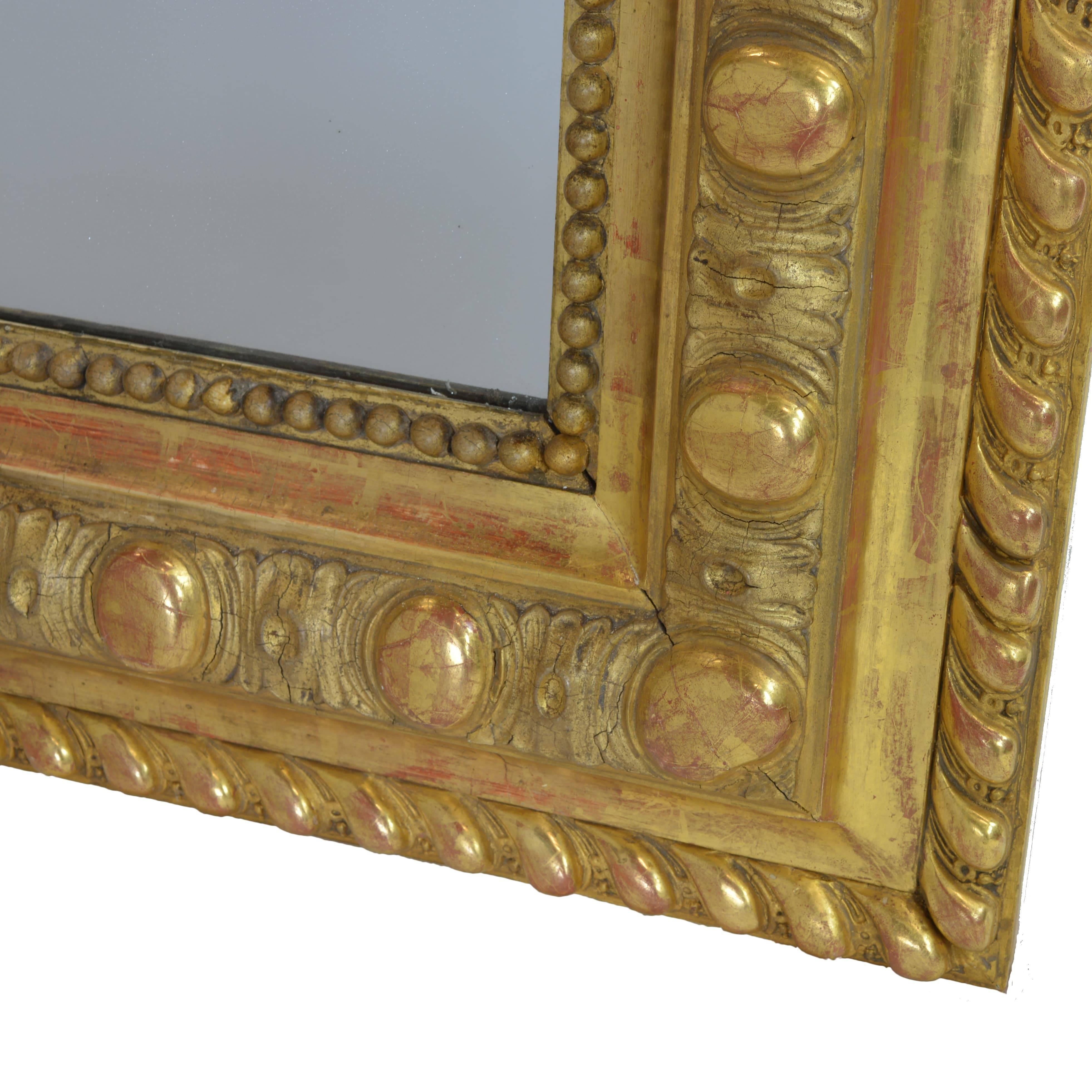 An extremely rare find. The artistic detail in the carved cherubs, floral garlands, and shield adorning the crown is such that it will hold any onlooker absolutely spellbound. The meticulously crafted, hand-carved wooden frame is gilded in
