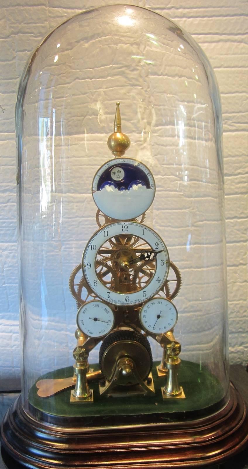 Skeleton clock in a glass dome, fusee movement,
with moon dial (rotates on a 24-hour cycle), day dial, date dial,
signed Franz Denk in Wien,
Measure: 32 x 22 x 52cm high.